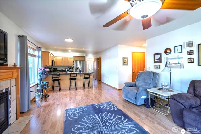 a living room with furniture kitchen view and a wooden floor