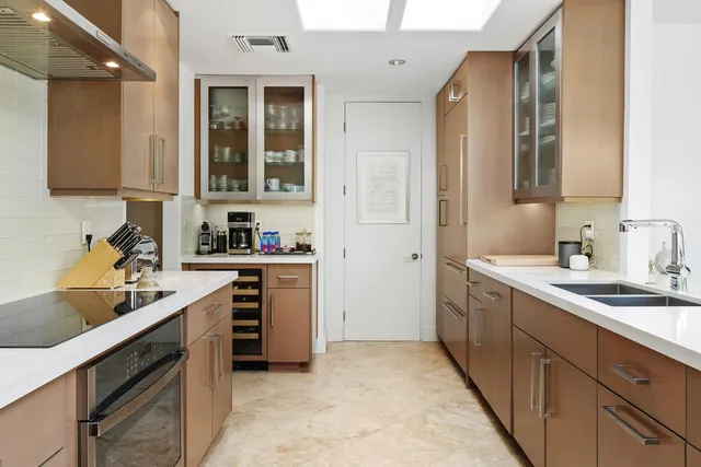 a large white kitchen with a large window and sink