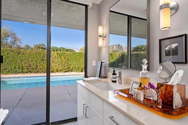 a bedroom with two beds and large windows