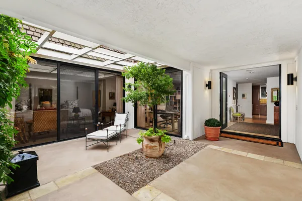 a view of a patio with table and chairs and potted plants