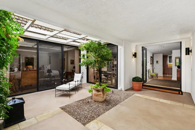 a view of a patio with table and chairs and potted plants