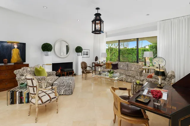 a living room with fireplace furniture and a large window