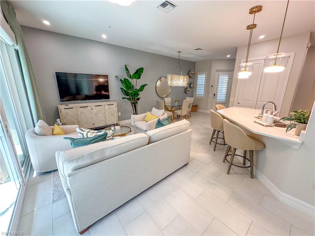 232 Indies Drive East, Unit 201 Naples, FL 34114 - Photo 11 of 49 a living room with furniture and a flat screen tv