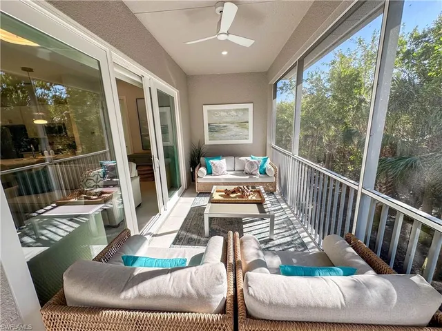 a living room with patio furniture and a large window