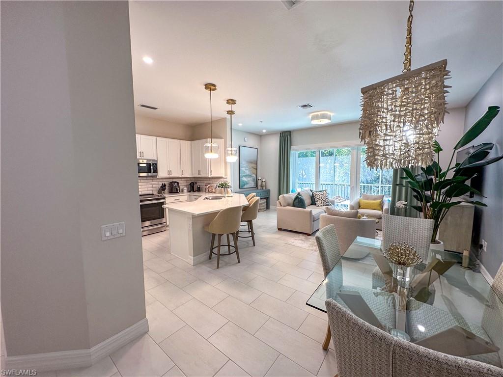 232 Indies Drive East, Unit 201 Naples, FL 34114 - Photo 2 of 49 a large kitchen with a table and chairs