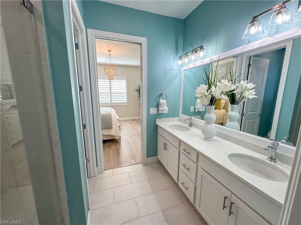 232 Indies Drive East, Unit 201 Naples, FL 34114 - Photo 23 of 49 a spacious bathroom with a double vanity sink and a mirror