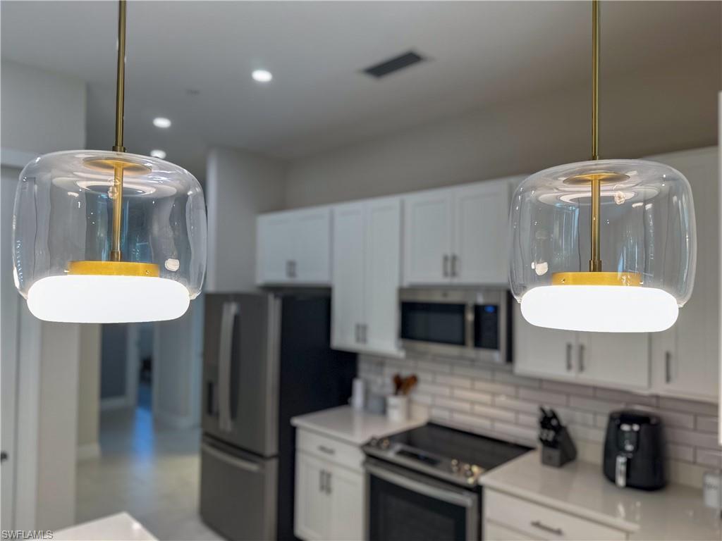232 Indies Drive East, Unit 201 Naples, FL 34114 - Photo 28 of 49 a kitchen with stainless steel appliances a stove a refrigerator and a sink