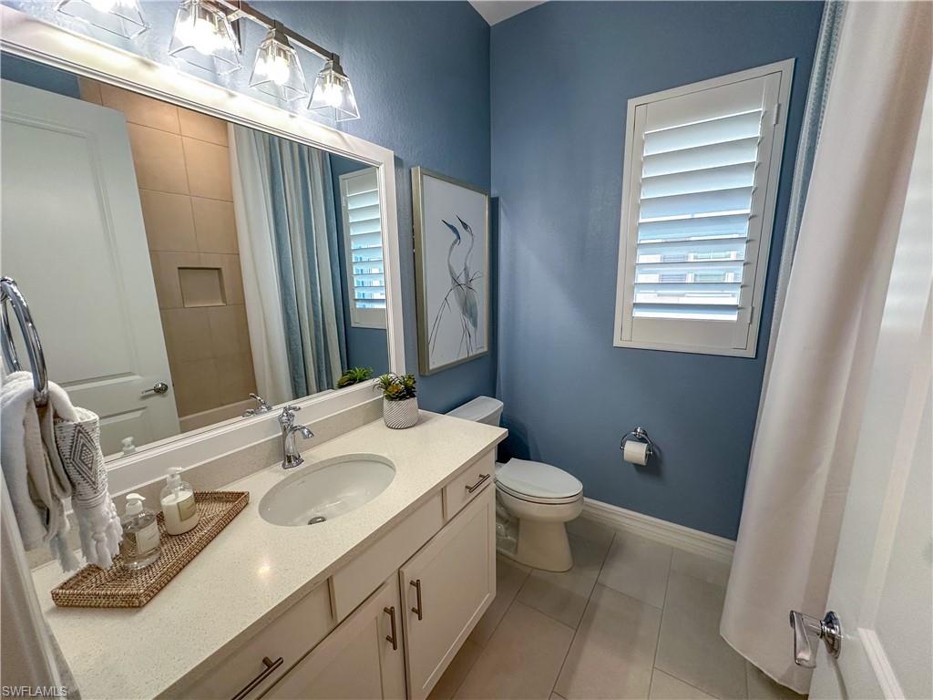 232 Indies Drive East, Unit 201 Naples, FL 34114 - Photo 30 of 49 a bathroom with a double vanity sink toilet and mirror