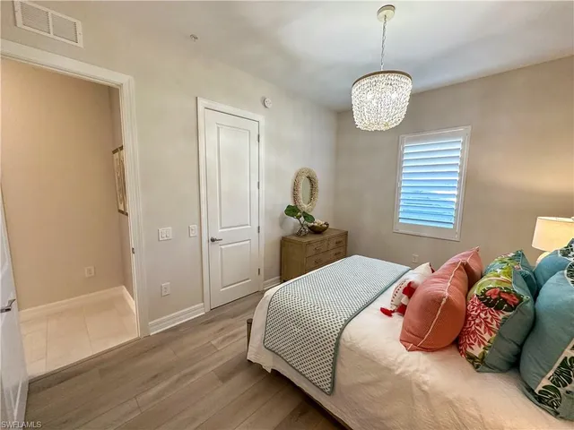 a bedroom with a bed and a chandelier