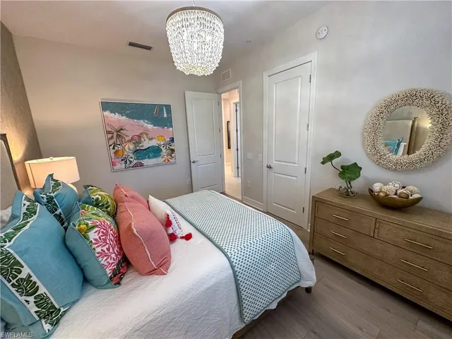 a bedroom with a bed and a chandelier