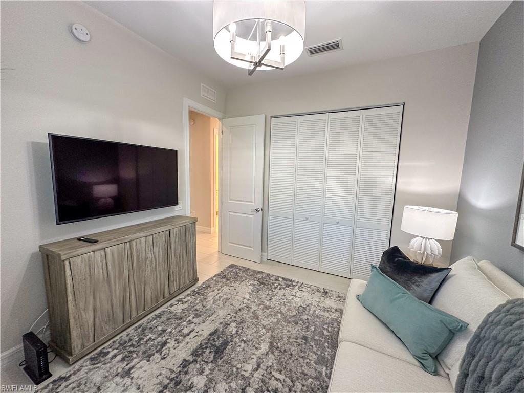 232 Indies Drive East, Unit 201 Naples, FL 34114 - Photo 39 of 49 a living room with furniture and a flat screen tv