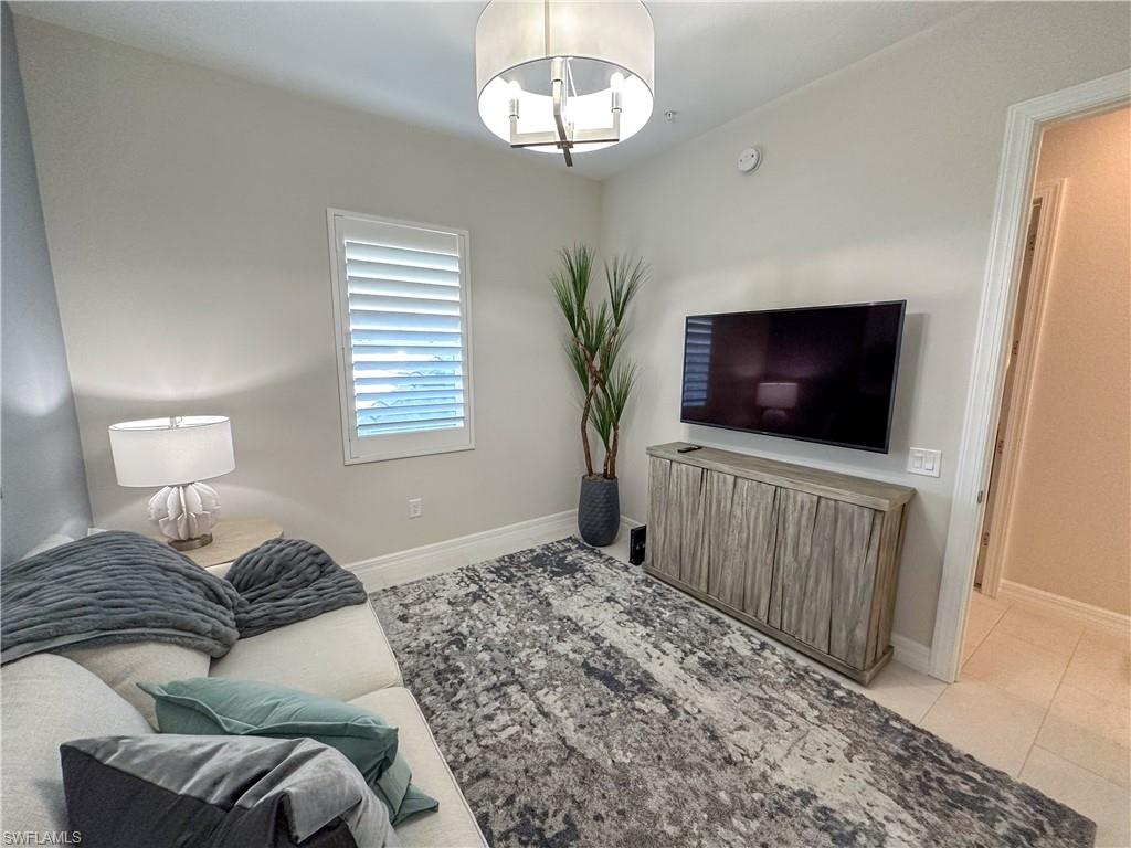 232 Indies Drive East, Unit 201 Naples, FL 34114 - Photo 40 of 49 a living room with furniture and a flat screen tv