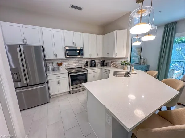 a kitchen with stainless steel appliances a stove a sink island and a refrigerator
