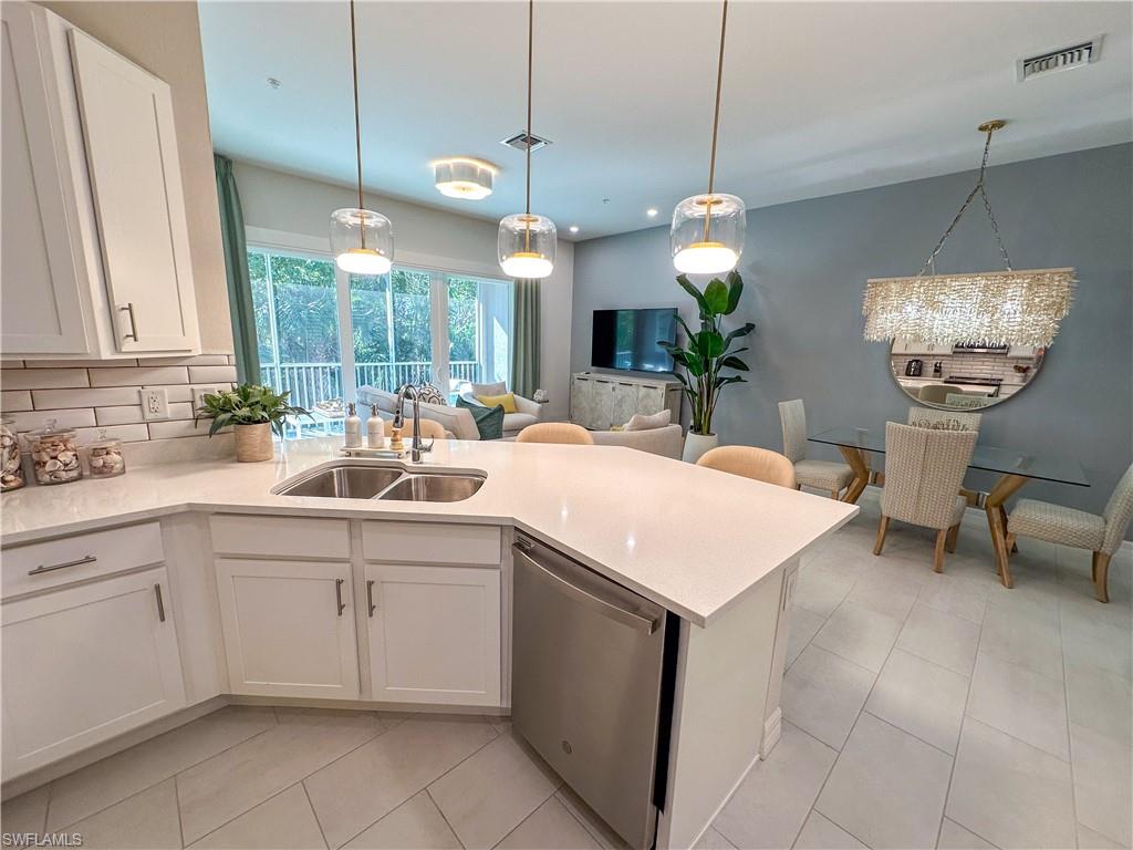 232 Indies Drive East, Unit 201 Naples, FL 34114 - Photo 7 of 49 a kitchen with a sink and chandelier