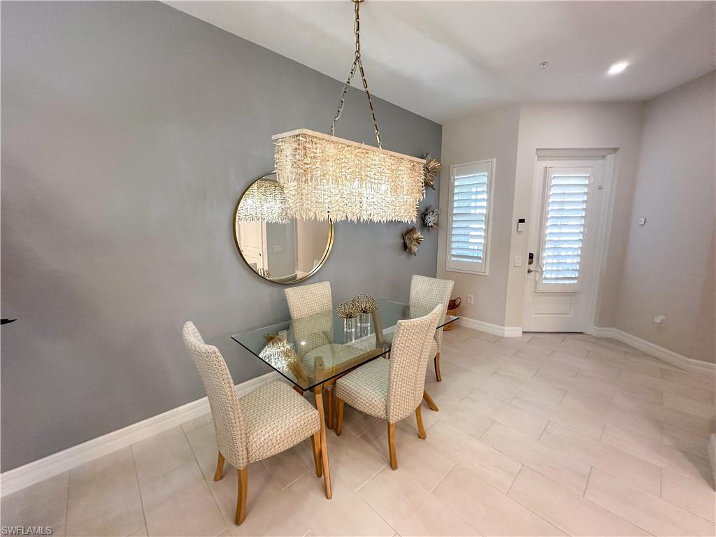 232 Indies Drive East, Unit 201 Naples, FL 34114 - Photo 8 of 49 a dining room with furniture and a mirror