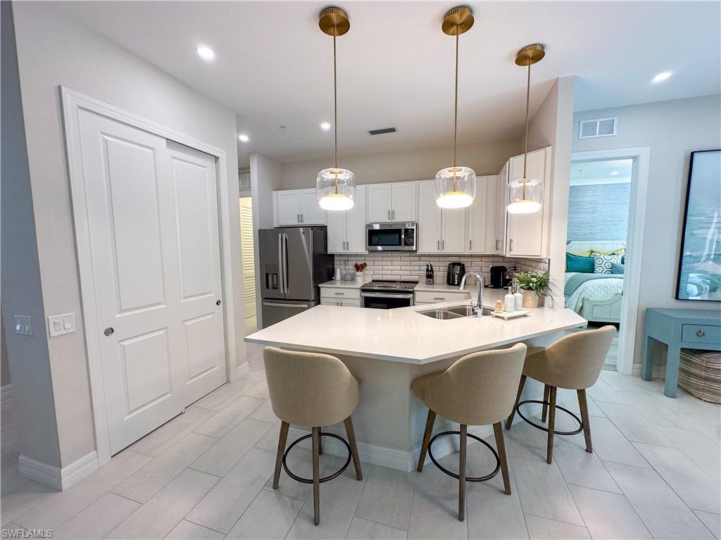 232 Indies Drive East, Unit 201 Naples, FL 34114 - Photo 9 of 49 a large kitchen with a table and chairs