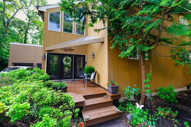 front view of a house with a small yard and potted plants