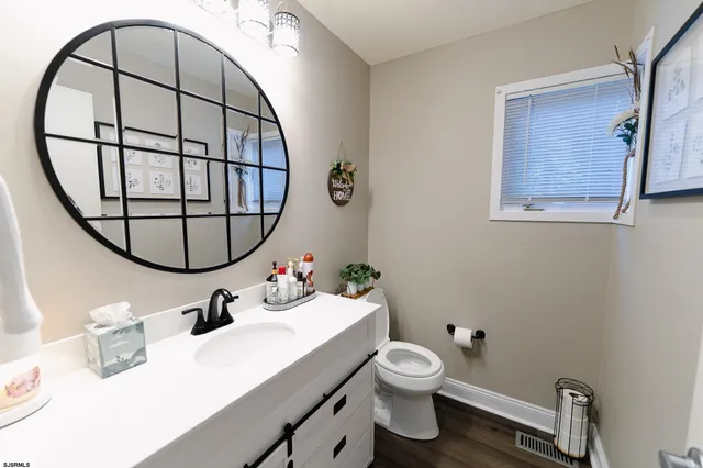 a bathroom with a sink mirror and toilet