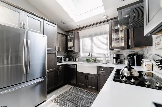 a kitchen with stainless steel appliances a refrigerator sink and cabinets