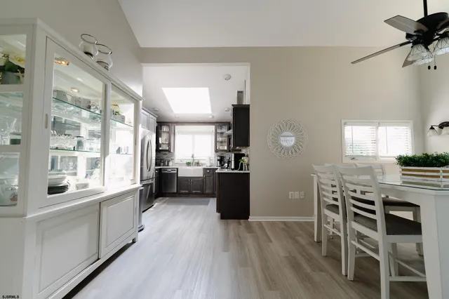 a kitchen with a table chairs a sink dishwasher stove and cabinets