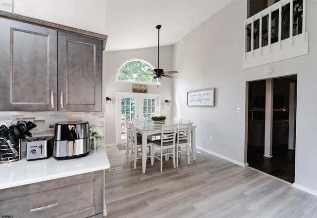 a dining room with wooden floor a chandelier a wooden table and chairs
