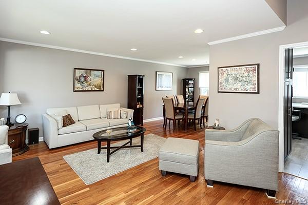 Hardwood flooring throughout, recessed lighting, crown molding, and an open-concept layout
