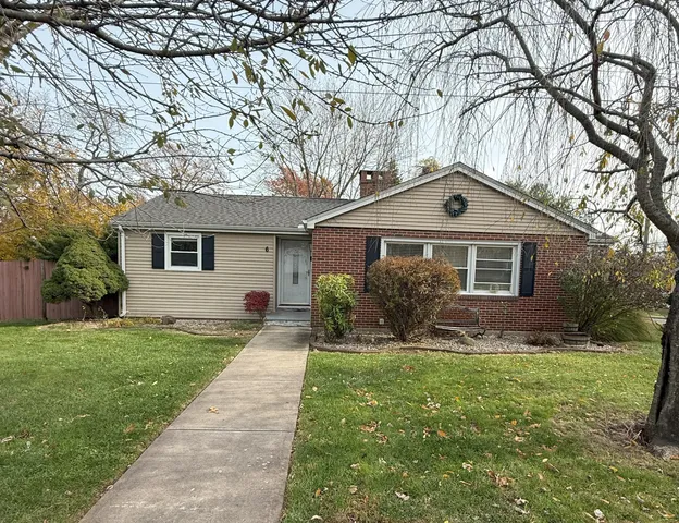 a front view of a house with a yard and trees