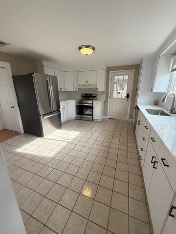 a kitchen with granite countertop a sink a stove top oven and cabinets