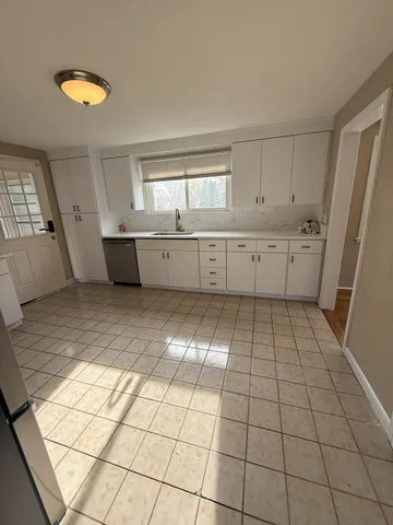 a kitchen with a sink a stove a window and cabinets