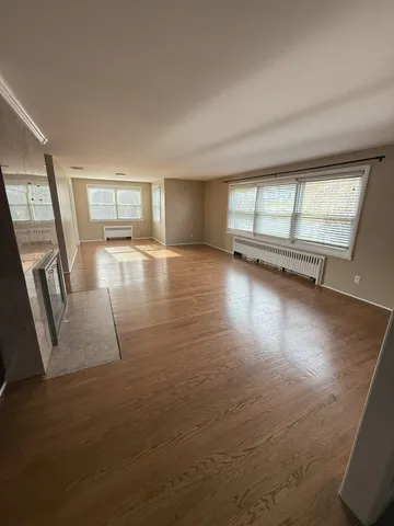 a view of a livingroom with wooden floor and window