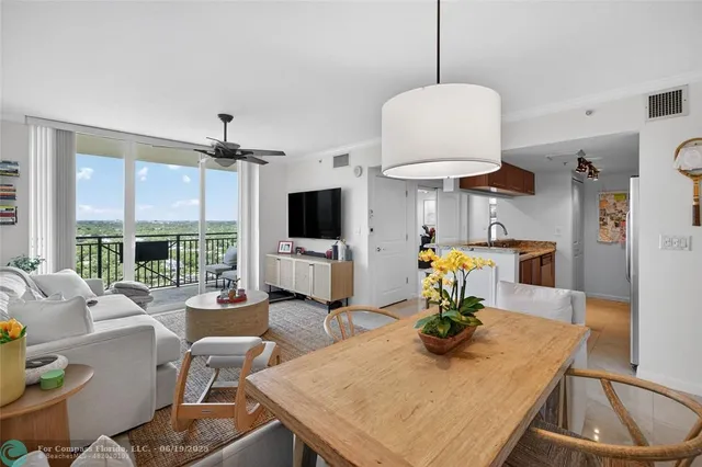 a living room with furniture a flat screen tv and kitchen view