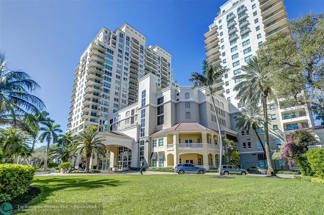 a view of a big building with a big yard and large trees