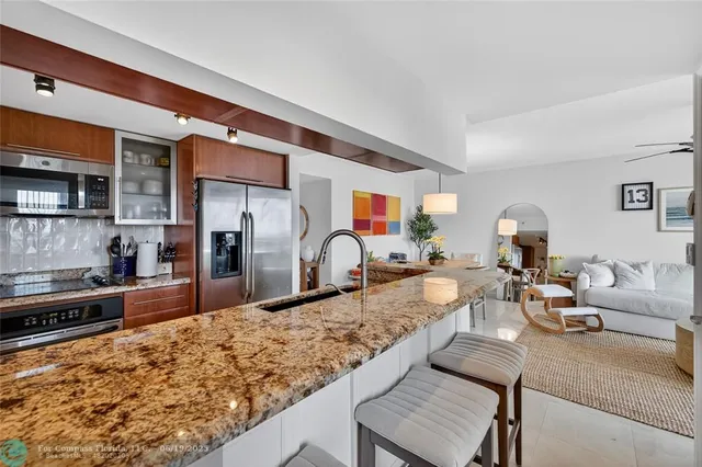 a kitchen with stainless steel appliances granite countertop a stove a sink and a microwave