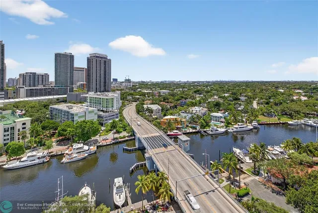 an aerial view of residential houses with outdoor space and trees