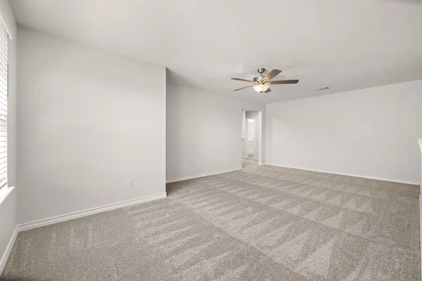 an empty room with a window and a ceiling fan