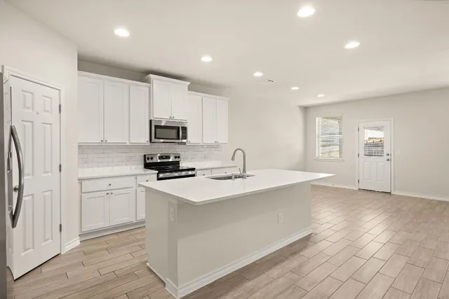 a kitchen with white cabinets and stainless steel appliances