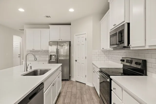 a kitchen with a sink stove and refrigerator
