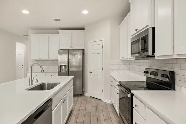 a kitchen with a sink stove and refrigerator