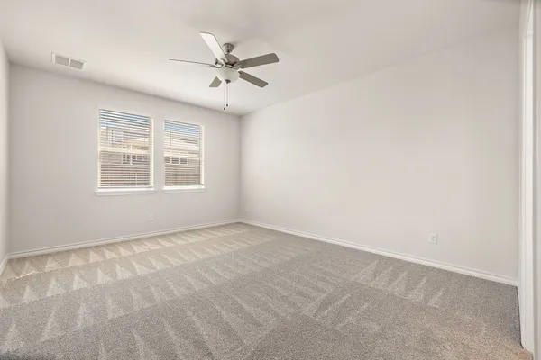 an empty room with a window and a fan