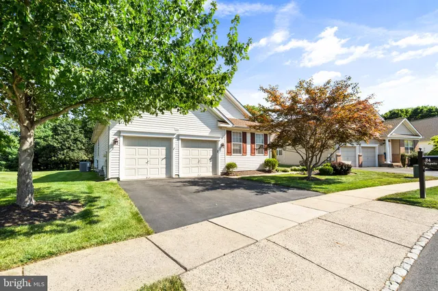 a front view of a house with a yard and trees