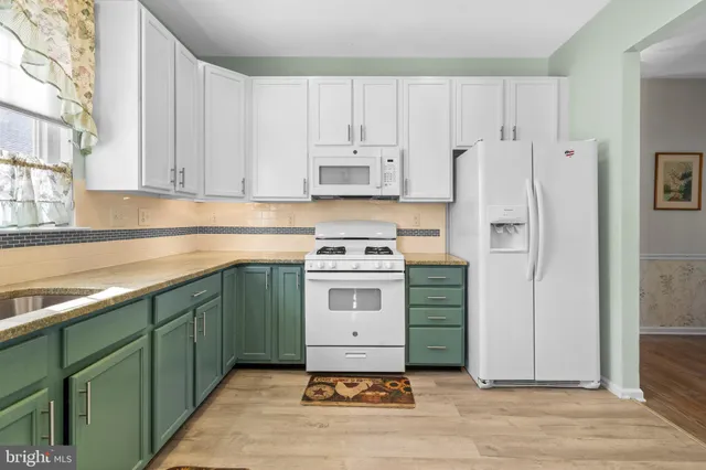 a kitchen with kitchen island a sink stainless steel appliances and cabinets