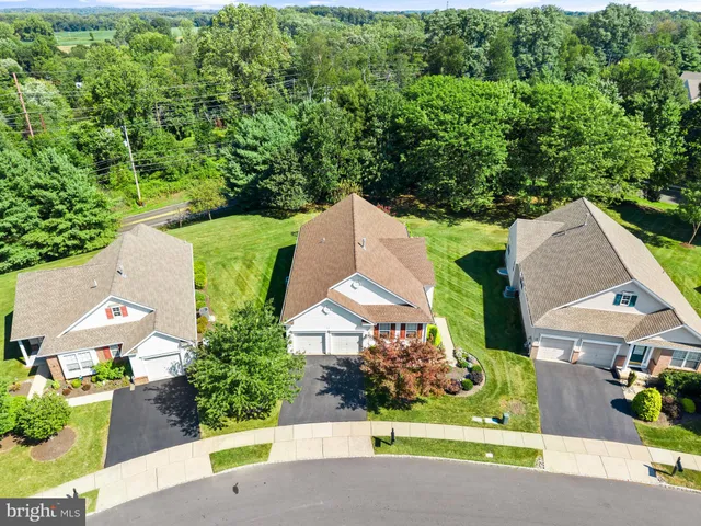 an aerial view of a house with outdoor space and trees all around