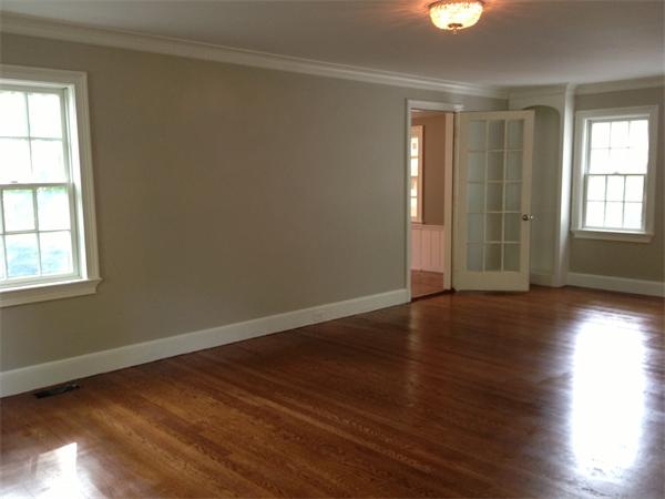 55 Fox Hill Road Wellesley, MA 02481 - Photo 4 of 10 an empty room with wooden floor and windows with curtains