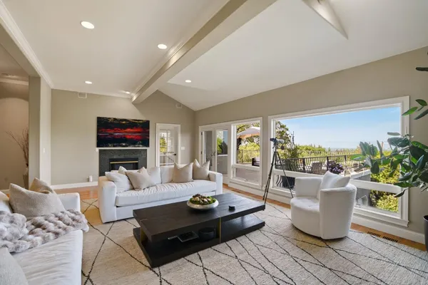 a living room with furniture a flat screen tv and a large window