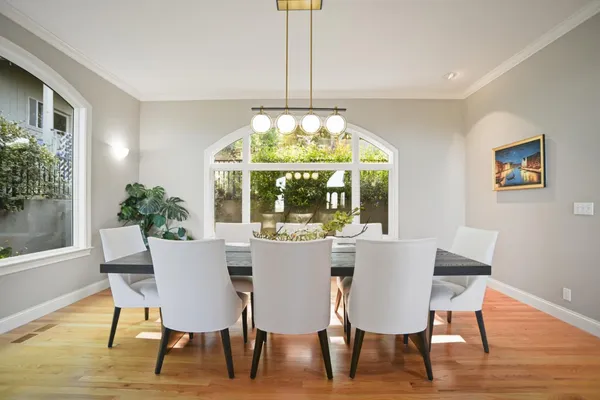 a dining room with furniture a chandelier and wooden floor
