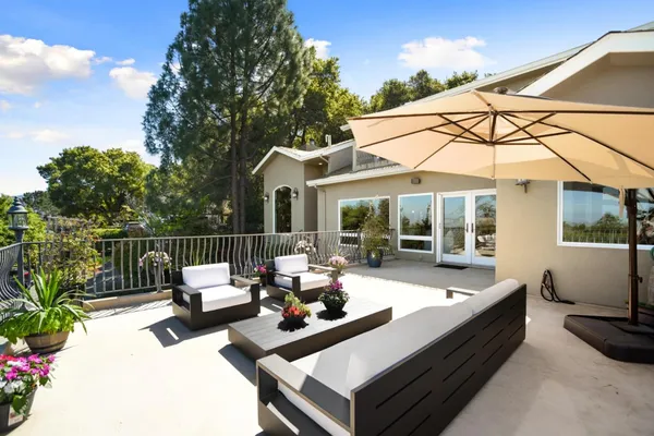 a view of a patio with couches table and chairs and potted plants