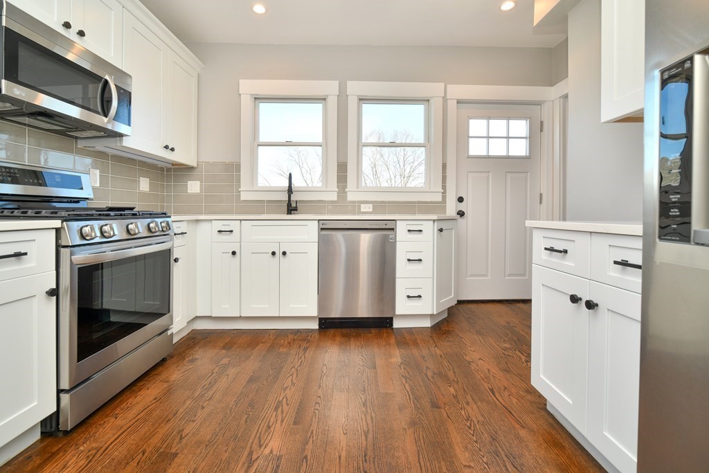 a kitchen with stainless steel appliances a stove top oven and cabinets