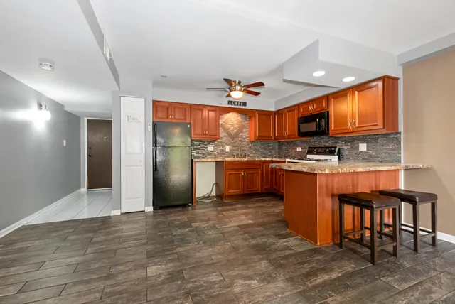 a kitchen with stainless steel appliances granite countertop a refrigerator a stove a sink and a microwave