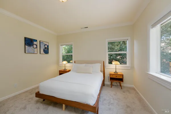 a bedroom with a bed and next to a window