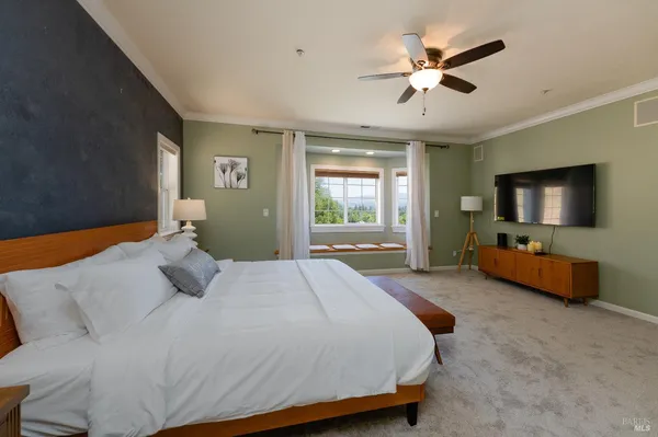 a bedroom with a bed flat screen tv and a couch